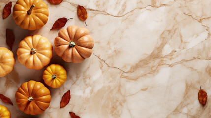 A group of pumpkins with dried autumn leaves and twig, on a tan color marble