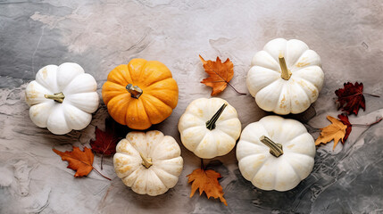 A group of pumpkins with dried autumn leaves and twig, on a dark white color marble