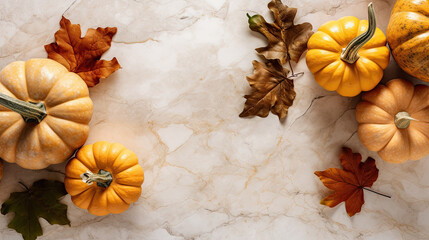 A group of pumpkins with dried autumn leaves and twig, on a light brown color marble