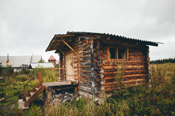 a small wooden cabin is sitting in the middle of a grassy field