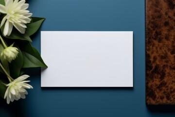 an elegant white business card set against a blue backdrop, featuring a white flowers