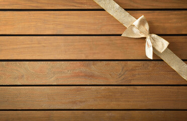 Background shiny gold bow in upper right corner on wooden
