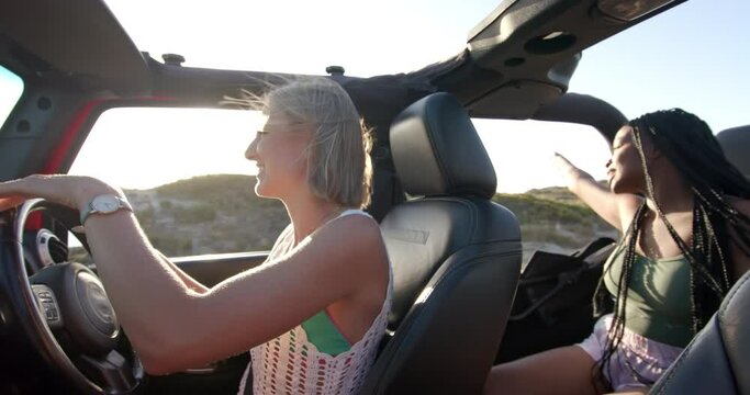 Young Caucasian woman drives a convertible on a road trip