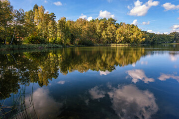 Natural landscape of the lake, high definition, the movement of waves against the background of the autumn forest. The reflection of clouds on the ripples of water. Germany. - 741371562