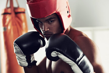 Sports, portrait and man boxer in gym for exercise, workout and combat training for competition. Breathing, health and shirtless male athlete fighter in boxing ring with gloves in fitness center.
