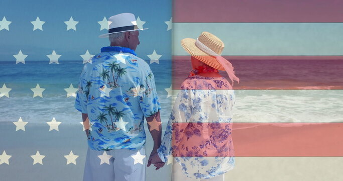 Image of flag of usa over diverse senior couple on beach in summer - Powered by Adobe