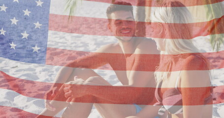 Image of american flag waving over smiling couple in love on beach