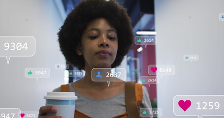 Image of media icons over african american businesswoman drinking coffee and smiling