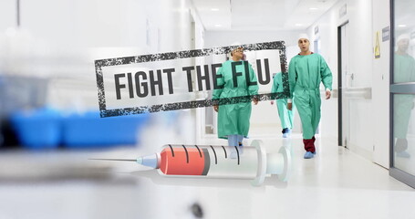 Image of fight the flue text and syringe over diverse surgeons in hospital
