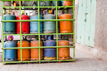 Colourful propane butane gas bottles stored on steel shelf