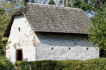 Old granary in Polish village with wooden tiles roof and white limestone clay facade