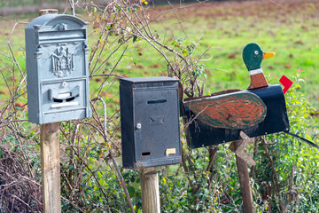 Old traditional post boxes on wooden poles at road in Monteriggioni  village, Italy
