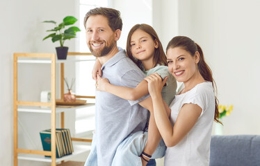 Family portrait of happy Caucasian young couple and their preteen daughter. Beautiful family of...