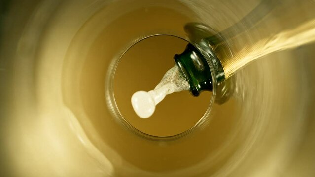 Super Slow Motion of Pouring Champagne Wine into Glass. Unique Perspective of View from Glass Bottom. Filmed on High Speed Cinema Camera, 1000 fps.