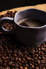 Vertical image of a cup of coffee with coffee beans.