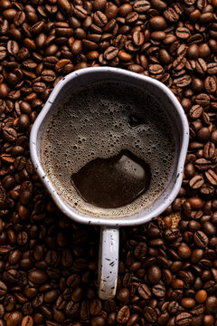 Top view. Cup of coffee with coffee beans. Vertical image
