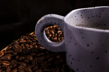 Closeup of a cup of coffee with coffee beans.