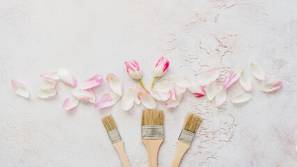 Drei Pinseln m it pinken Tulpen und Blütenblättern auf einem grauen Hintergrund. Flat lay,...