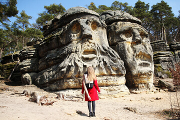 Girl in rad stay near Devil's Heads in Zelizy, Czech Republic