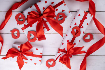 a group of valentine s day gifts wrapped in white paper with red ribbons and bows