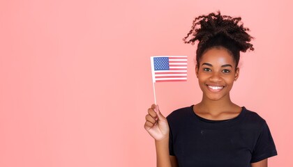 Portrait of a smiling afro american woman holding USA flag and looking up isolated on a pink background