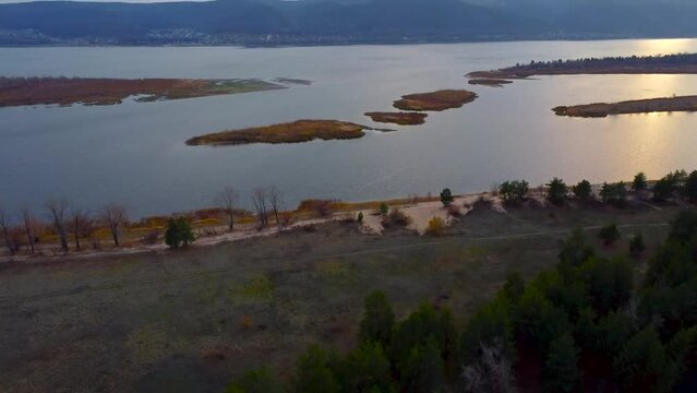 Autumn Overlook Aerial Views of Volga River, Forest, and the Grushinsky Festival Meadow in Warm Glow. Nature of Russia view from a drone in autumn