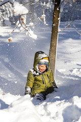 Fototapeta na wymiar little boy playing in winter forest