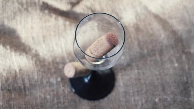 wine bottle corks falling into an empty glass goblet. slow motion.Elegant wine experience: corks and glass.Corks in a glass: unusual wine decor