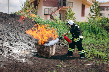 A firefighter is using a fire extinguisher to put out a fire