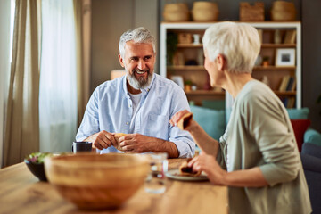 Fototapeta na wymiar A happy senior adult married couple talking and enjoying breakfast together on a lovely morning