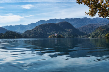 
Lake Bled, Slovenia - October 18, 2021: A long distance view of Bled Island in Autumn, amid a green and blue natural landscape