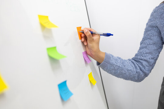 Organizing tasks with colorful sticky notes on whiteboard