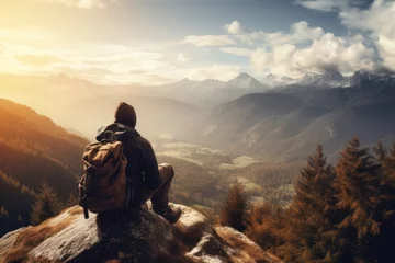 Deurstickers Young male tourist with a large backpack in the mountains and looking at the mountains © Elena