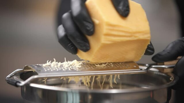 Grating cheese close-up. Food preparation and recipes concept.