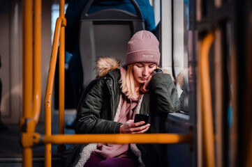 Fototapeta na wymiar Relaxed Young Woman Smiling on City Bus with Smart Phone