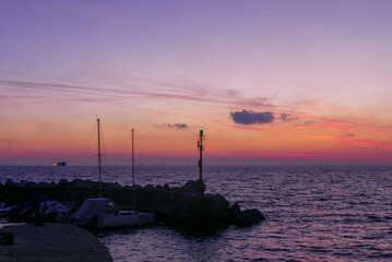 Sea at sunset with nautical light of a marina