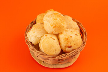 Brazilian cheese bread isolated inside a wooden basket in a clean background in front view