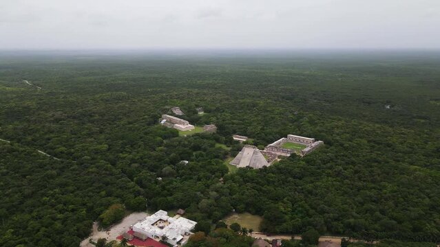 Aerial view of Uxmal Archaeological Zone ruins surrounded by lush green jungle, Yucatan, Mexico.