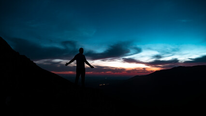 Spectacular sunset in the mountains with the silhouette of a man
