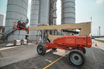 Male industry working at high in a boom liftinspection tank silo