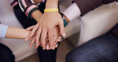 A diverse group of individuals are stacking their hands on top of each other symbolizing teamwork unity and collaboration