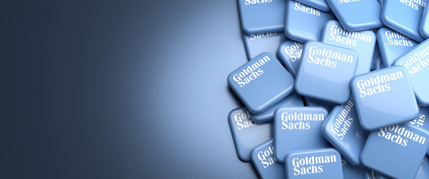 Logos of the American investment bank and financial services company Goldman Sachs on a heap on a table. Copy space. Web banner format.