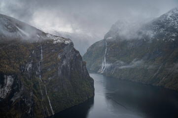 Panoramic image of the fjords of Norway in autumn, at sunset, with the Geiranger waterfalls.
