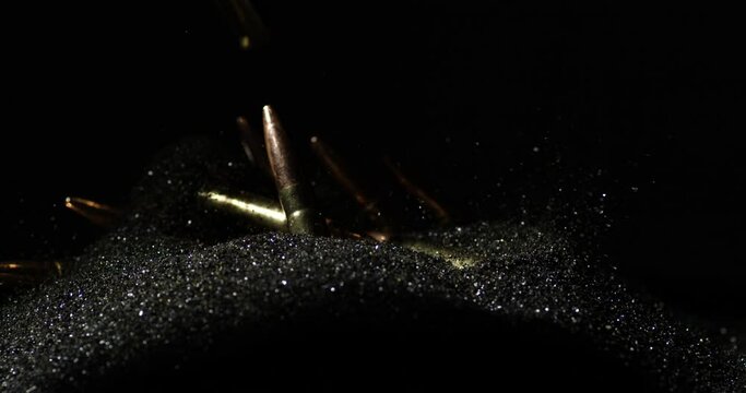 .300 AAC Blackout Cartridges Falling Into Gunpowder Against Black Backdrop. slow motion