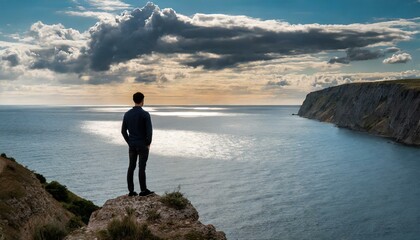 silhouette of a person on a cliff