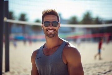 Portrait of a handsome young man in sunglasses at beach volleyball court