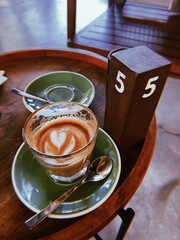 Delicious coffee with latte art on wooden table at cafe in the morning. Morning coffee. Soft focus....