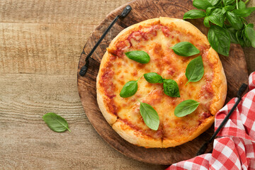 Margarita pizza. Traditional neapolitan margarita pizza and cooking ingredients tomatoes basil on wooden table backgrounds. Italian Traditional food. Top view. Mock up.
