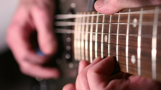 Guitarist's fingers playing on fretboard