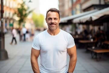 portrait of a handsome middle aged man smiling at the camera in the city - obrazy, fototapety, plakaty
